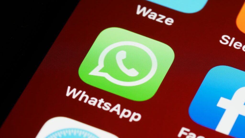 Icônes WhatsApp et Facebook sur un smartphone, deux canaux clés de la génération de leads en Haïti