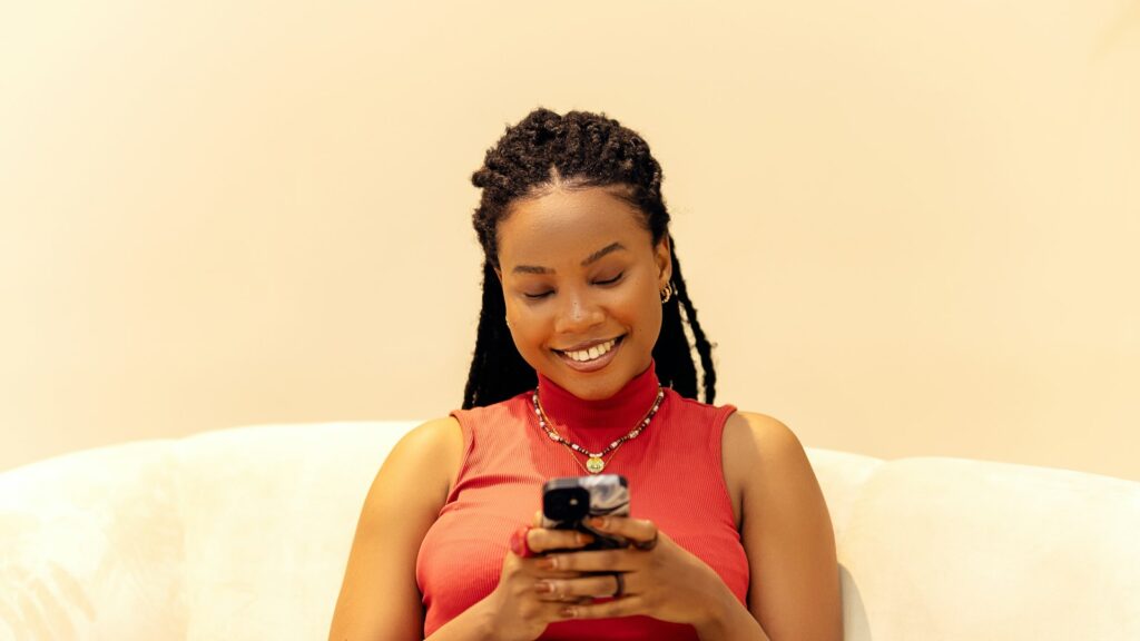 Cliente souriante qui transfère un message de recommandation depuis son téléphone