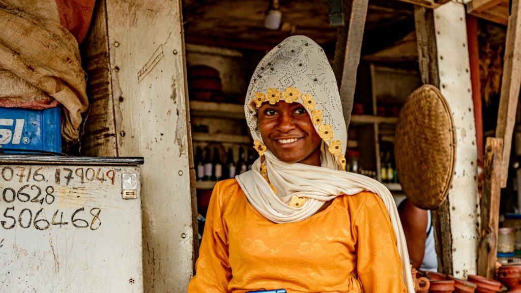 Commerçante souriante dans sa boutique, téléphone à la main